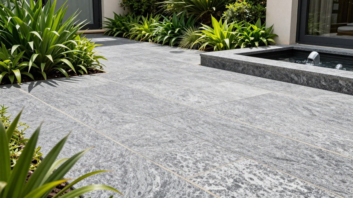 Granite paving slabs on a sunny patio with plants.