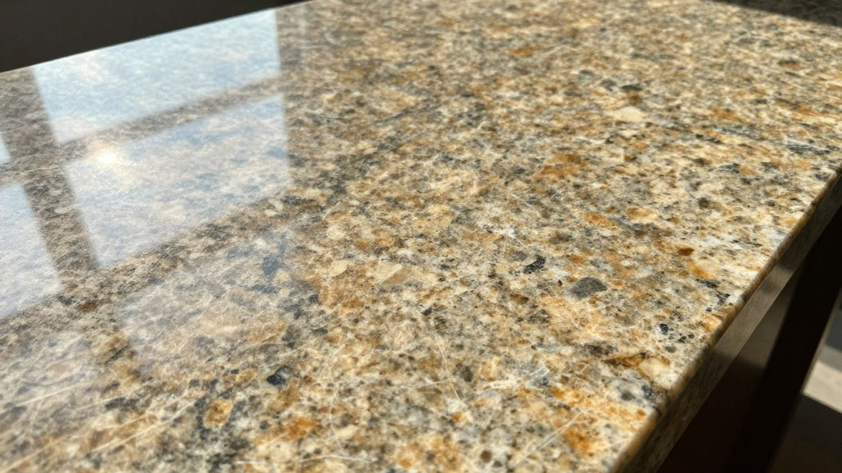 Polished granite countertop with natural patterns and sunlight.