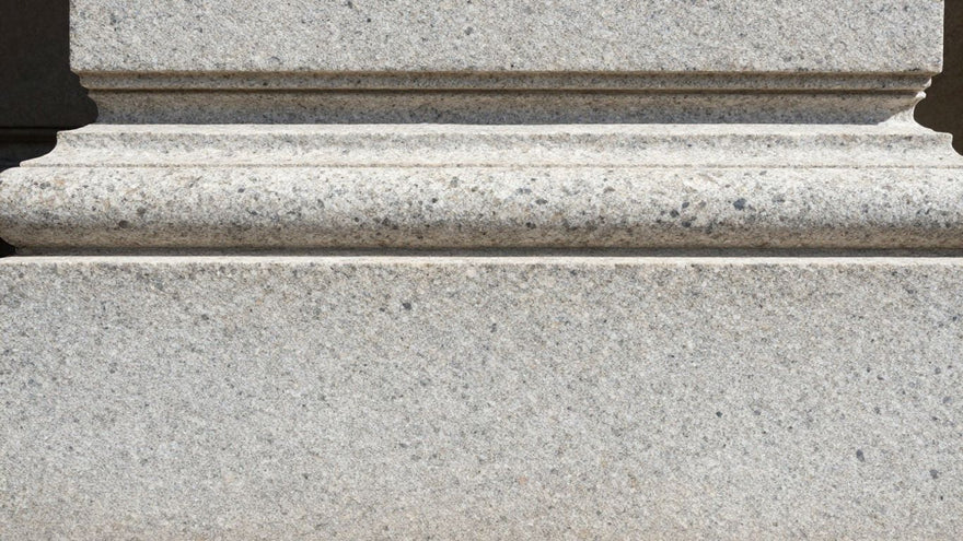 Polished granite building facade, showing texture and strength.