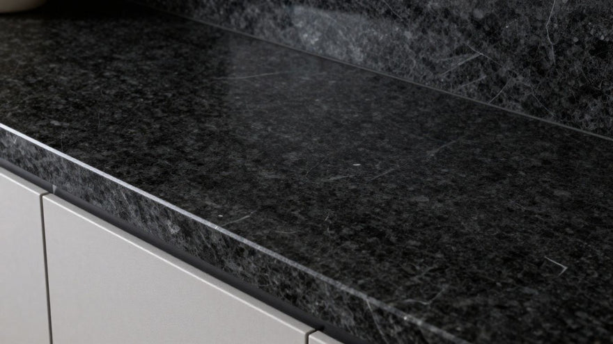 Sleek black granite kitchen worktop reflecting light.