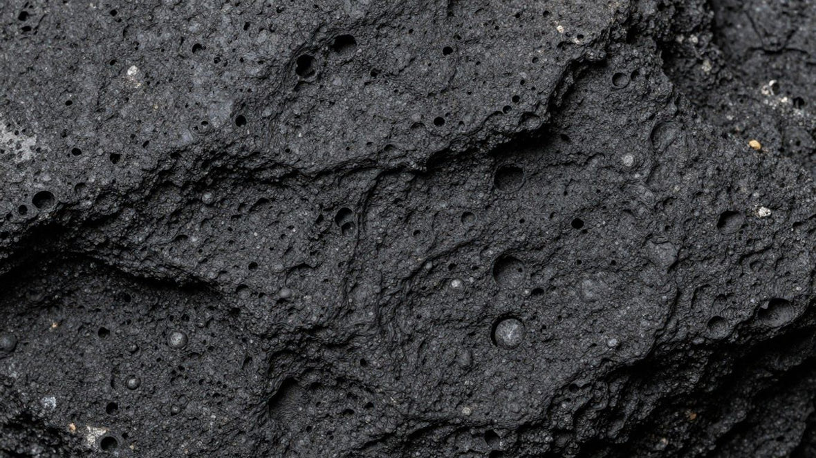 Close-up of dark, vesicular basalt rock with visible bubbles.